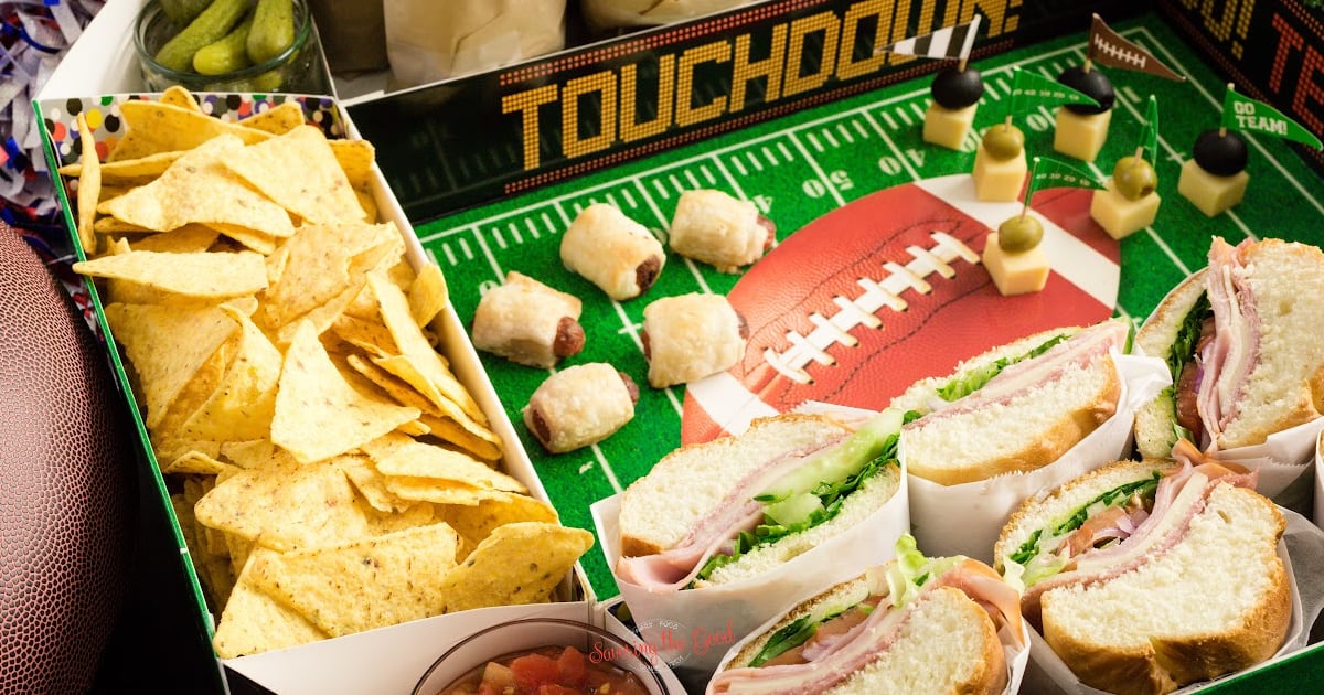 A football themed snack box with sandwiches, chips and dips.