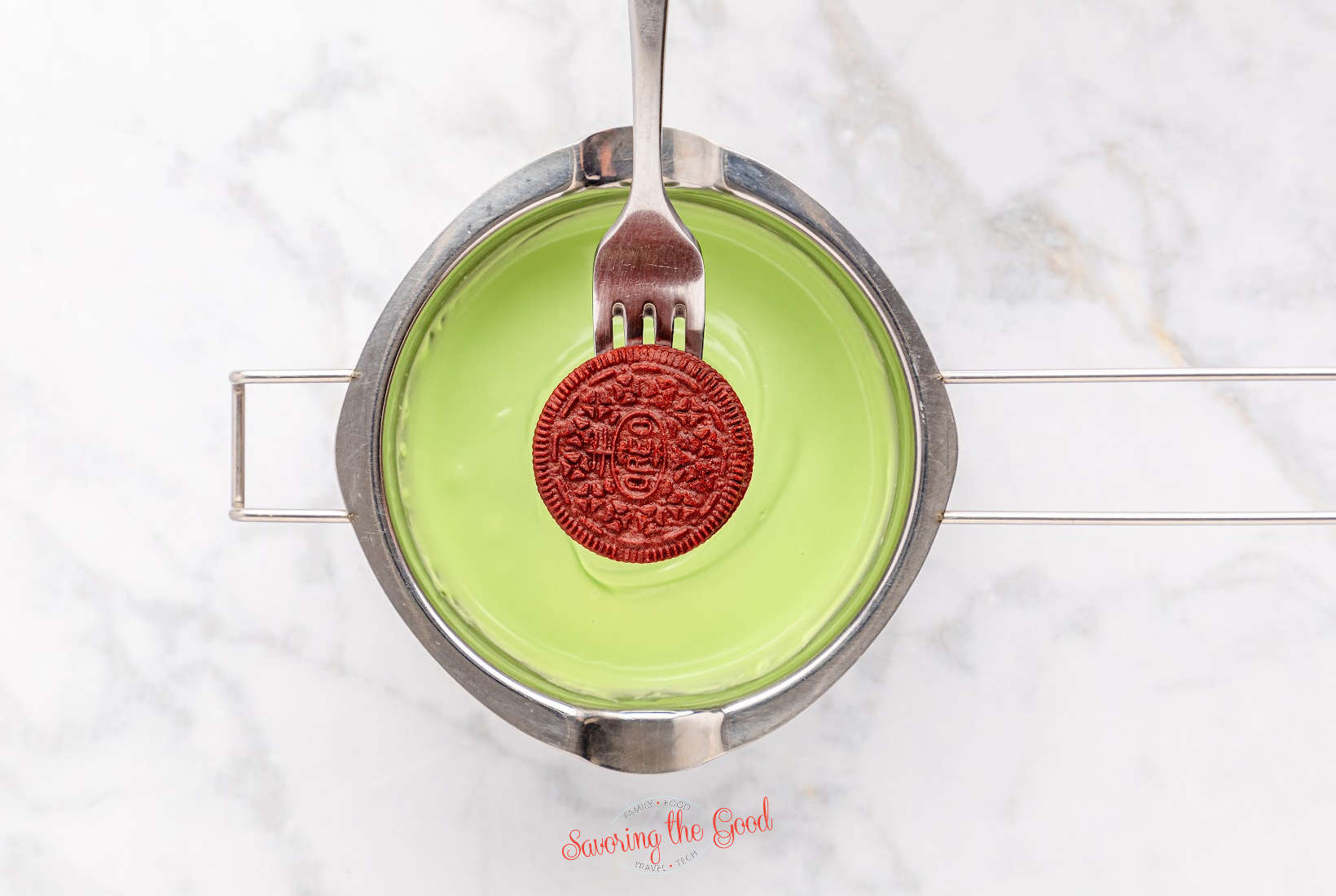 A Grinch-themed oreo cookie with a fork in it.