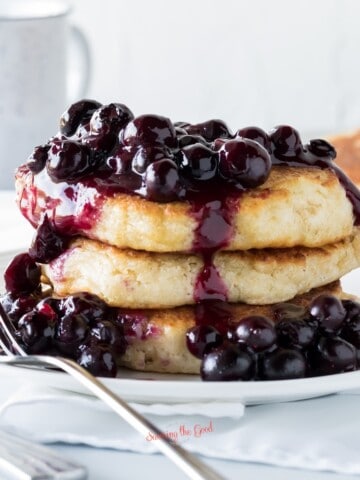 A stack of frozen blueberry pancakes on a white plate.