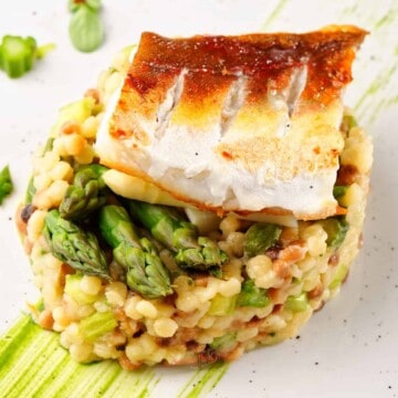 A plate of sea bass with asparagus and risotto.