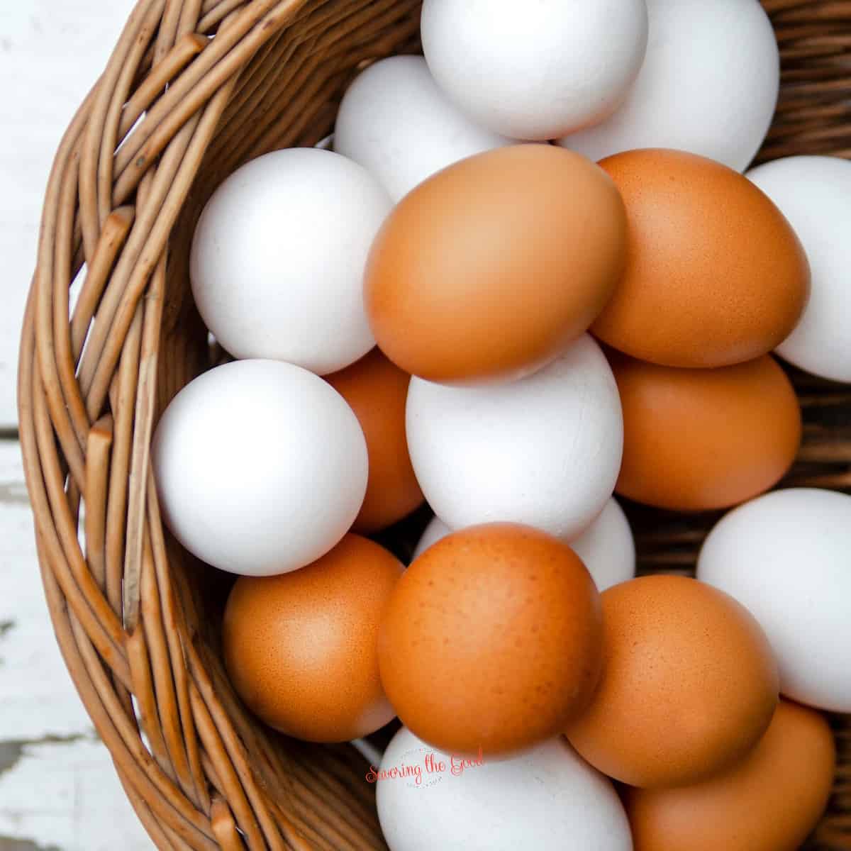 White and brown eggs in a wicker basket, showcasing 100 ways to prepare an egg.