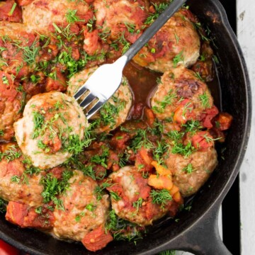 Turkey meatballs in tomato sauce cooked in a skillet.