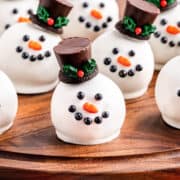 Snowman chocolate truffles on a wooden board.