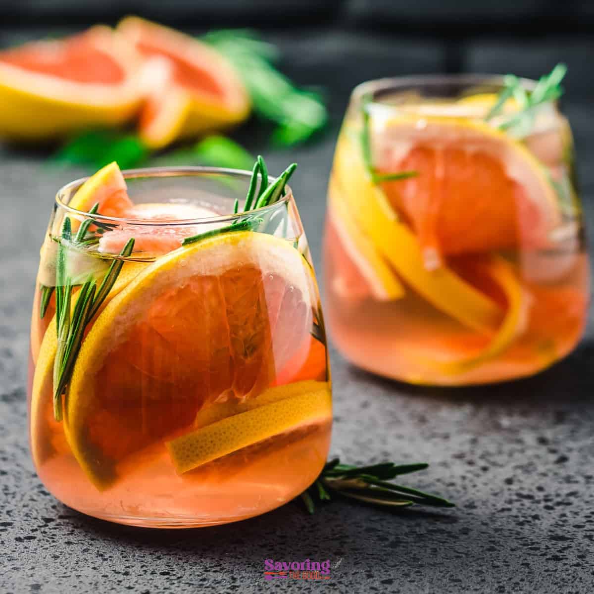 2 beverages with grapefruit and rosemary in them.