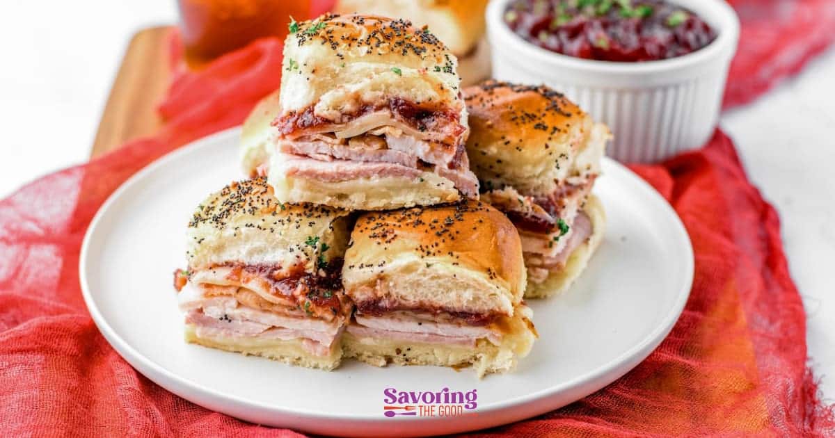 turkey hawaiian roll sliders stacked on a white plate.