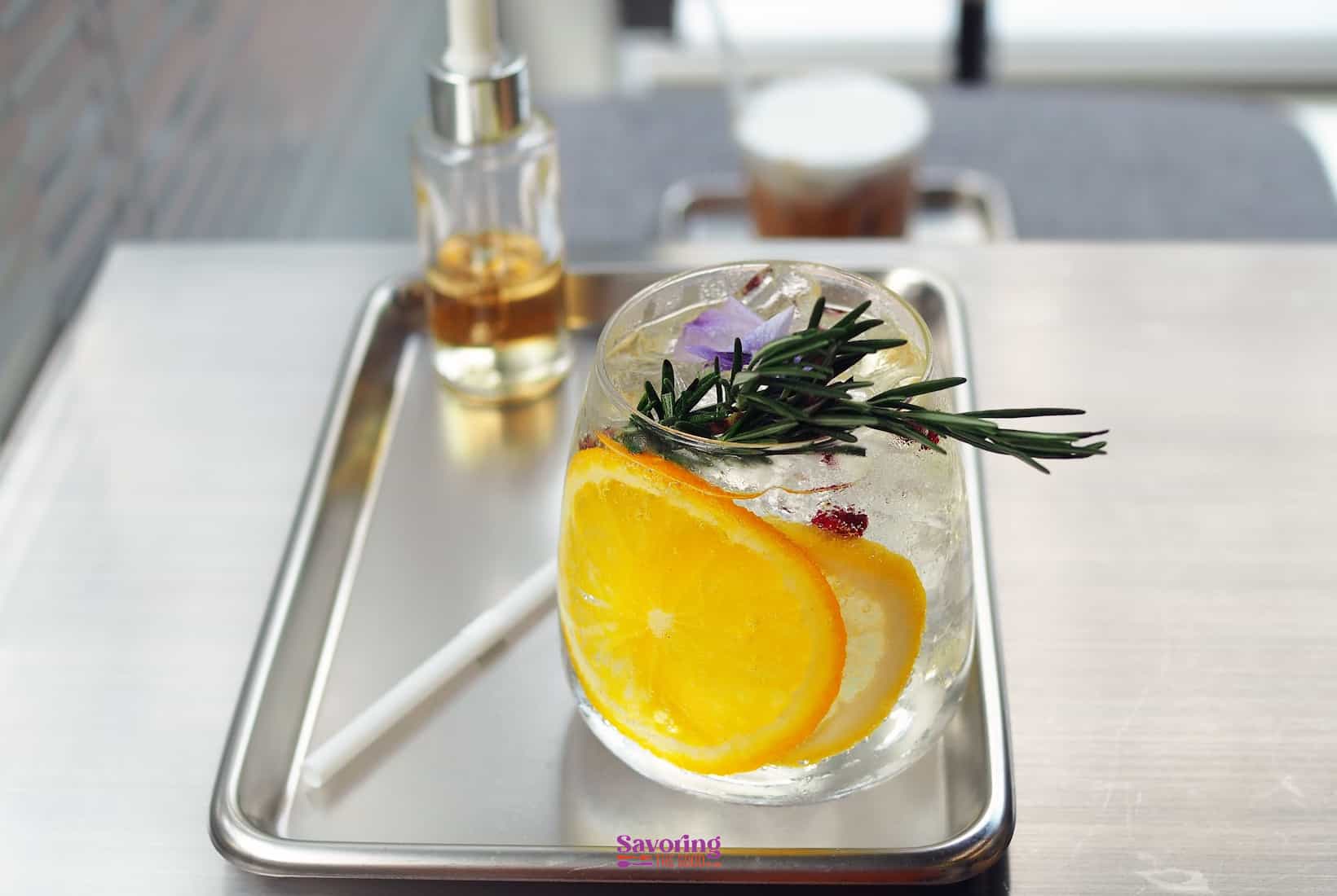 mocktail in a clear glass on a stainless tray.