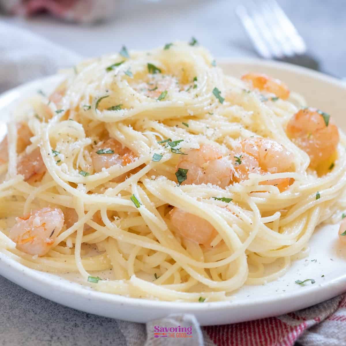 Shrimp scampi cooked with spaghetti and topped with parmesan cheese.