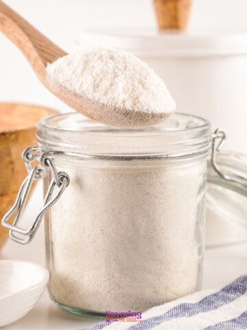 Homemade White flour in a jar with a wooden spoon.