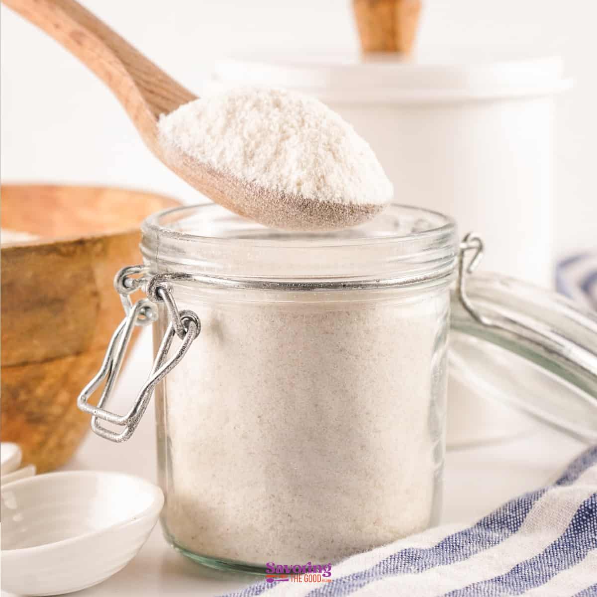 Homemade White flour in a jar with a wooden spoon.