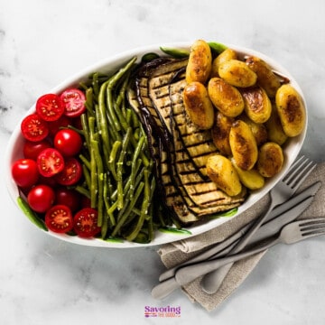 A white plate with green beans and potatoes, perfect side dishes for pork roast.