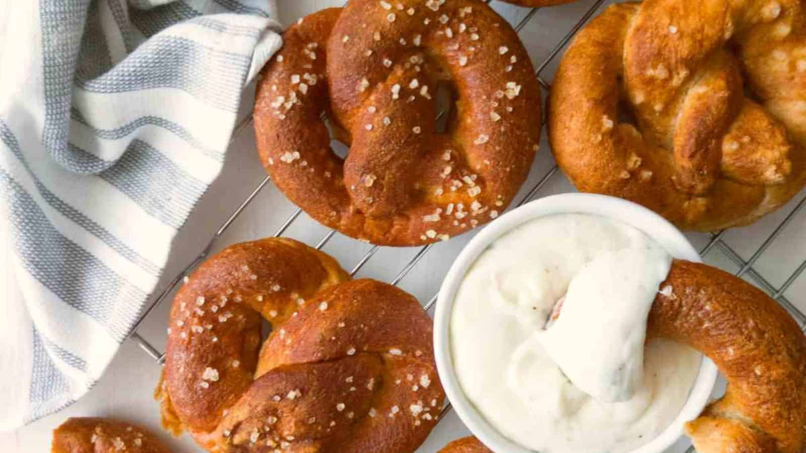 A pretzel and a bowl of dip.
