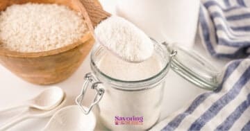 White rice flour in a glass jar next to a spoon and spoons.
