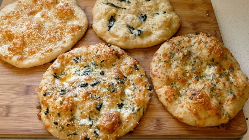 A group of flat breads on a wooden surface.