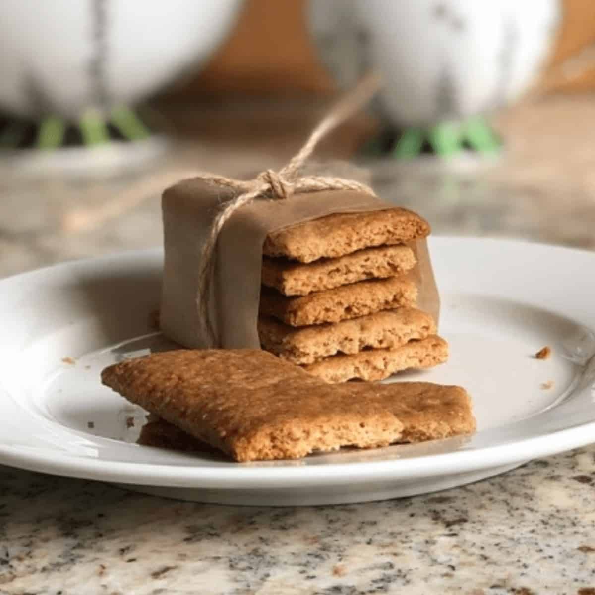 A stack of graham crackers on a white plate.