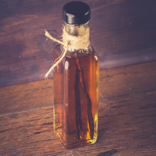 A bottle of vanilla extract on a wooden table.