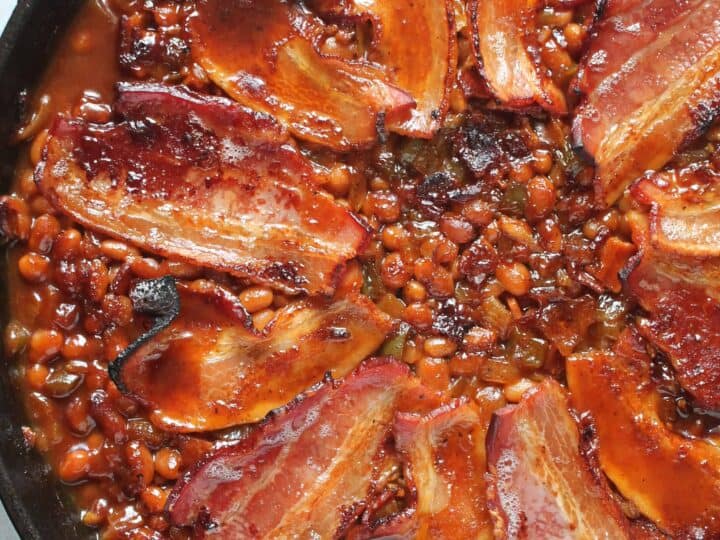 A skillet filled with beans and bacon.