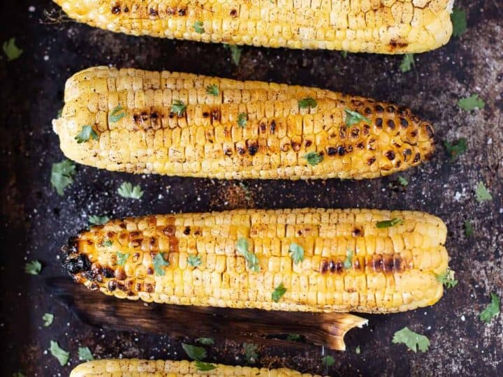 Grilled corn on the cob with lime wedges.