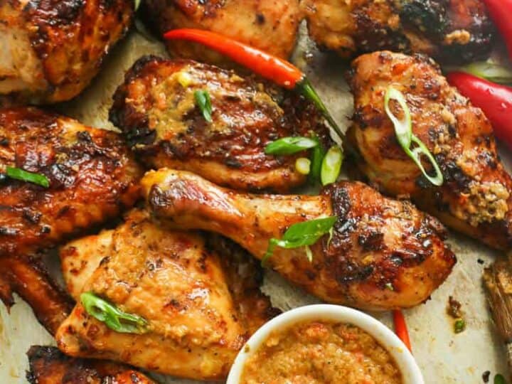 Grilled chicken with sauce on a baking sheet.