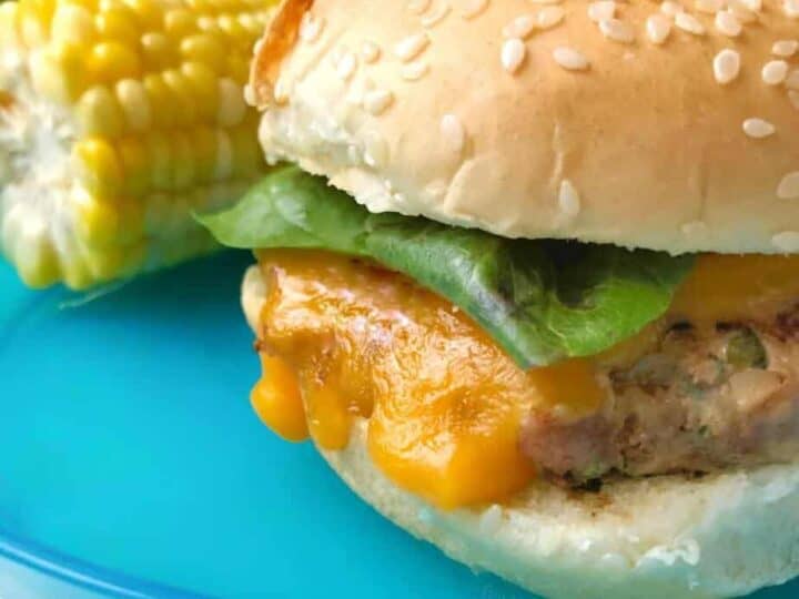 A burger and corn on a plate.