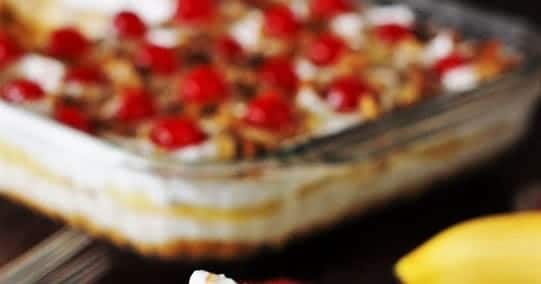 A slice of banana cream pie with cherries on top.