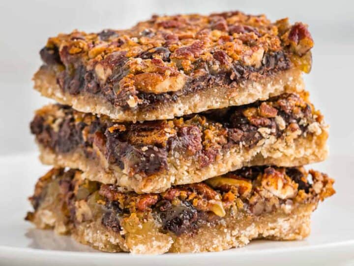 A stack of pecan bars on a plate.