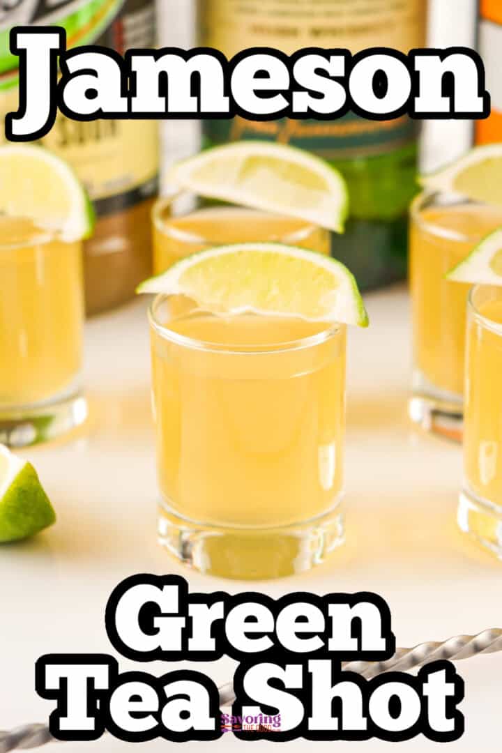 A glass of Jameson green tea shot garnished with a lime wedge, surrounded by similar shots on a table.