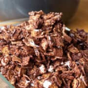 A close-up of golden graham s'mores cereal bars with melted marshmallow in a glass dish.