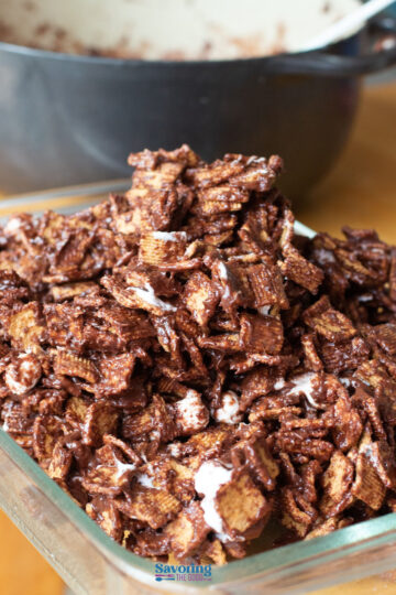 A close-up of golden graham s'mores cereal bars with melted marshmallow in a glass dish.