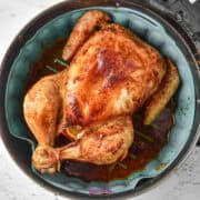 Air fryer chicken roasted to perfection inside the basket, boasting a golden-brown, crispy skin.