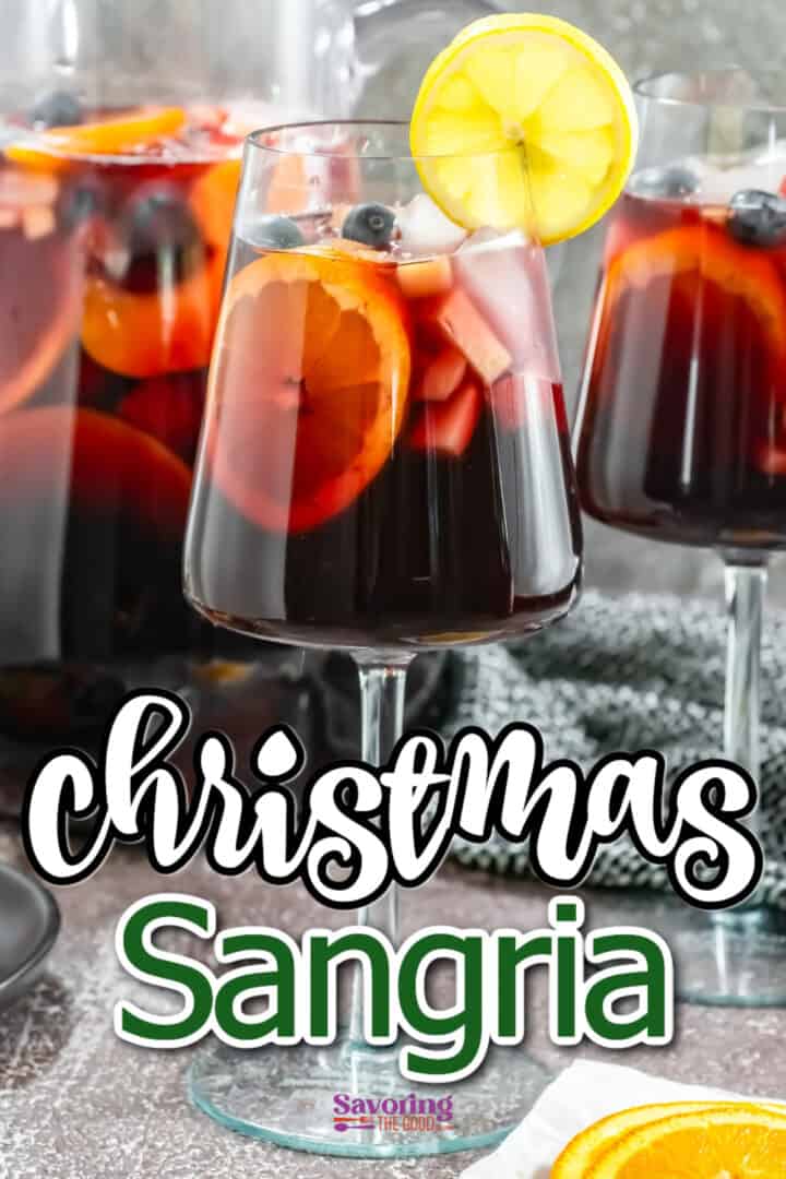 Glasses of sangria with fruits, garnished with a lemon slice and blueberries. The text reads "Christmas Sangria.