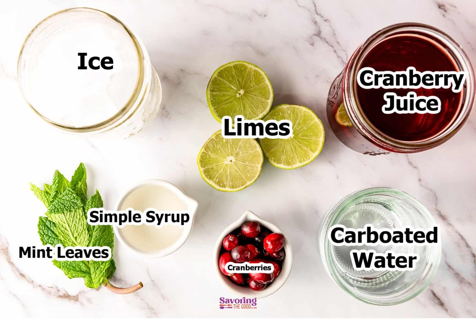 Ingredients for a refreshing cranberry mocktail are elegantly arranged on a surface: ice, cranberry juice, lime halves, simple syrup, mint leaves, carbonated water, and a small bowl of cranberries.