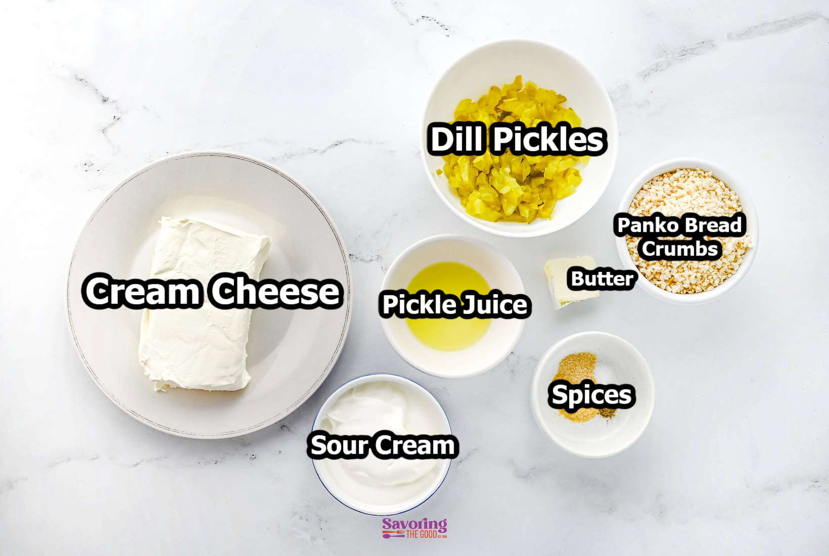 An arrangement of ingredients for a fried dill pickle dip, including cream cheese, dill pickles, sour cream, pickle juice, panko bread crumbs, butter, and spices in bowls on a white surface.