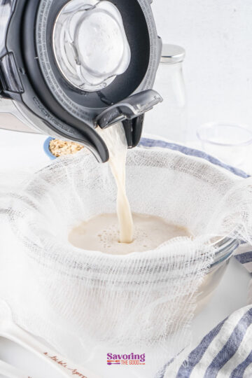 A machine pours liquid through a cheesecloth-lined strainer into a bowl, part of a kitchen setup for making homemade milk.