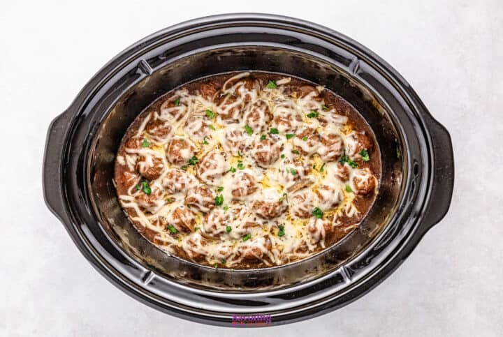 Crockpot French onion meatballs, perfectly slow-cooked with cheesy goodness and topped with fresh herbs in a rich, dark sauce.