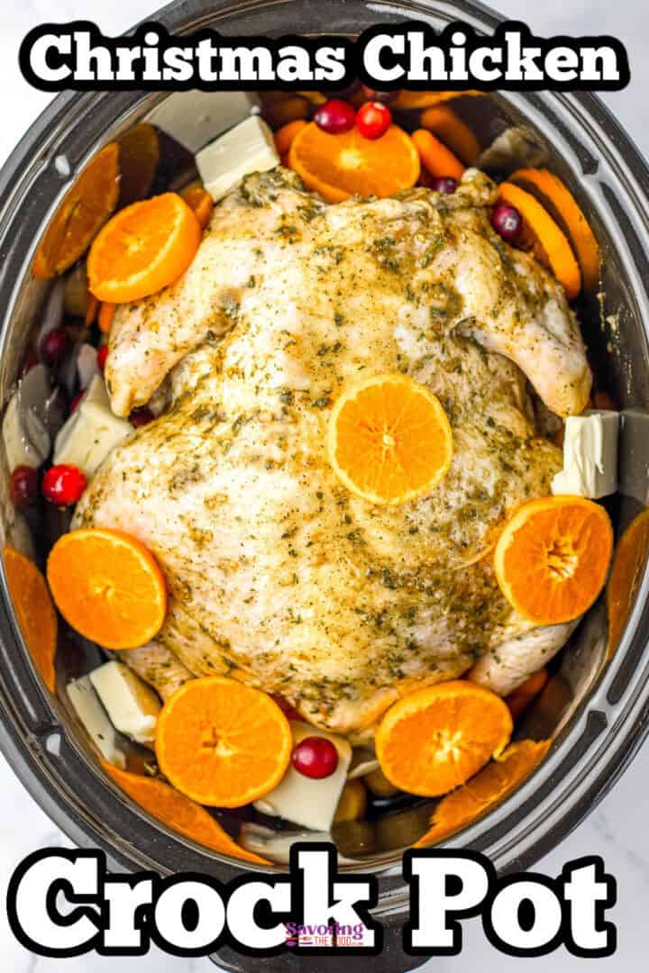 A whole chicken in a crock pot, seasoned and garnished with orange slices, cranberries, and herbs.