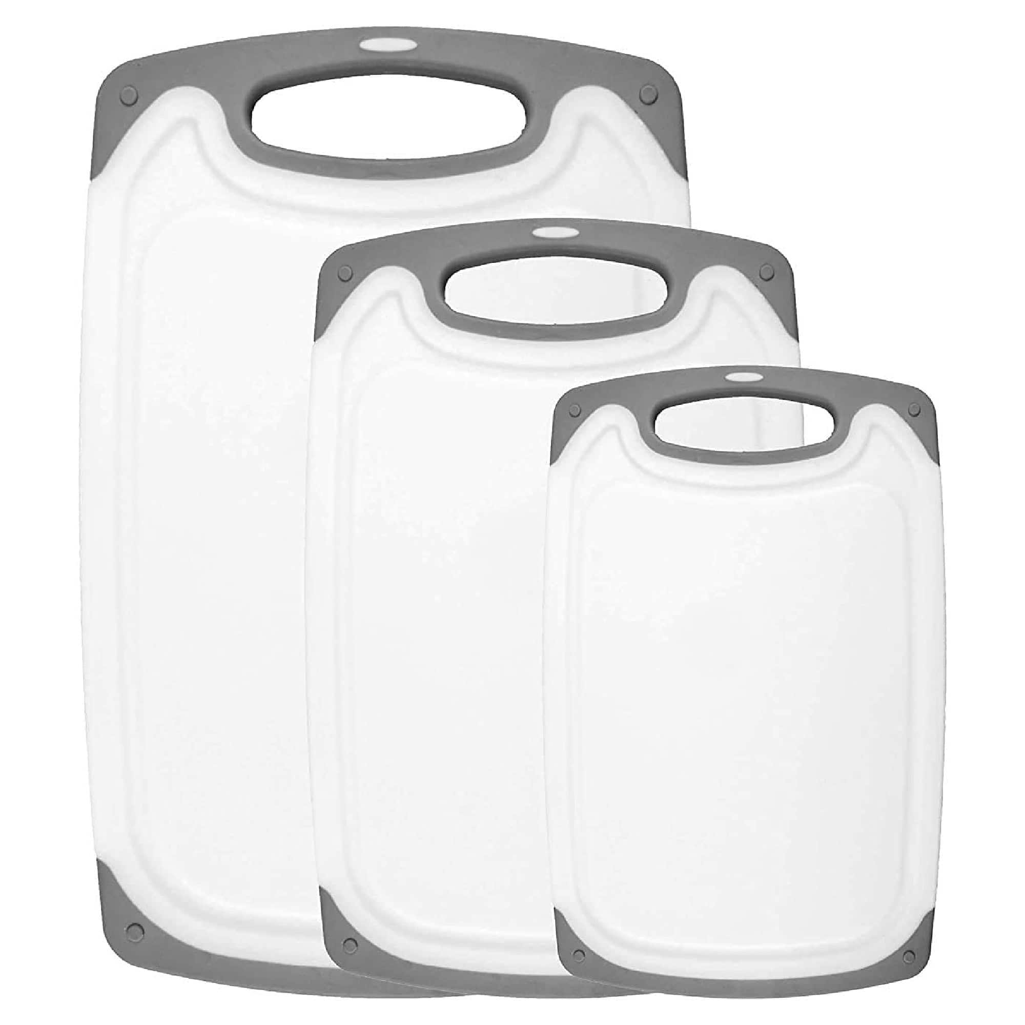Three white plastic cutting boards with gray trim and handles, arranged in descending size order.