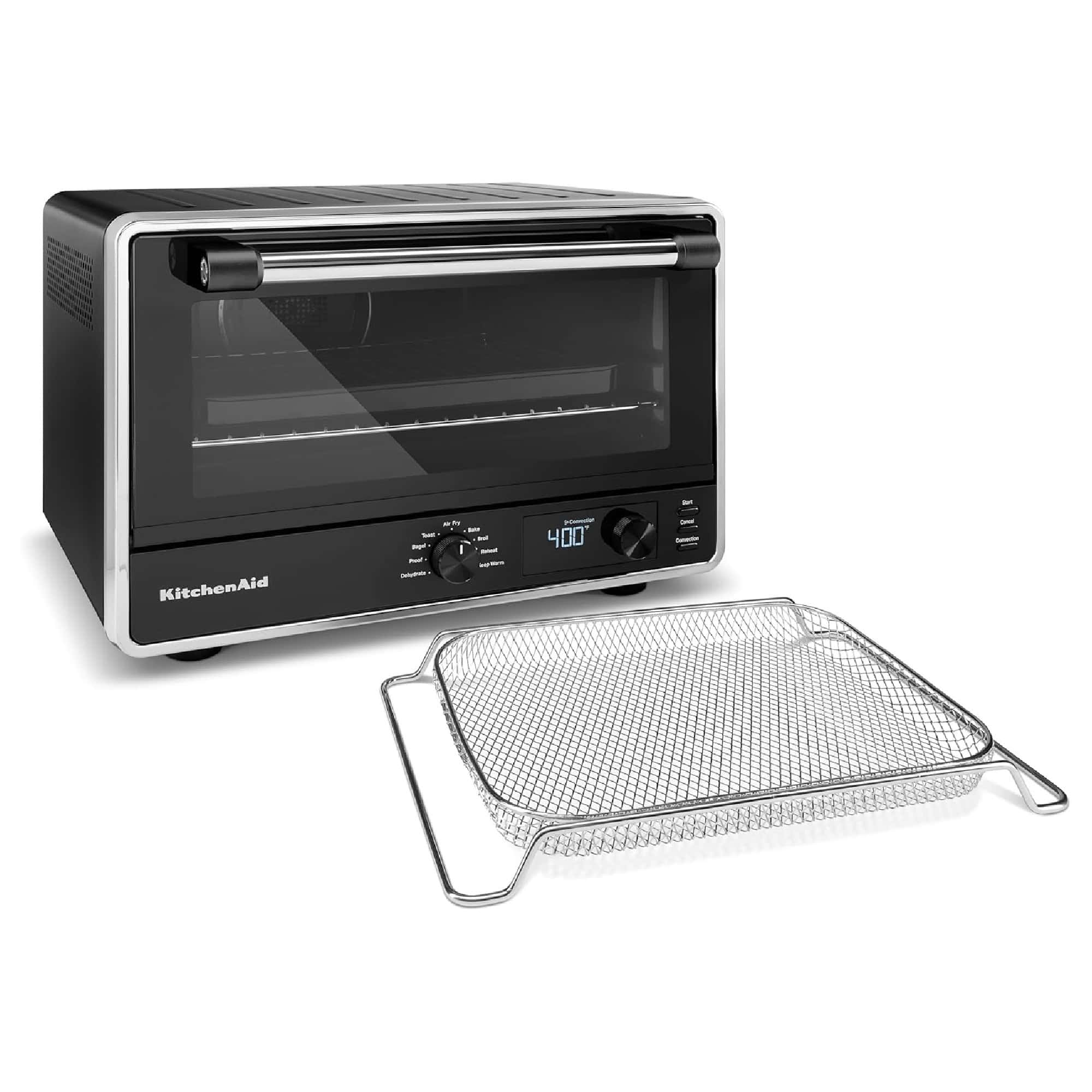 A black KitchenAid toaster oven with a digital display. A metal mesh tray is placed in front of it.