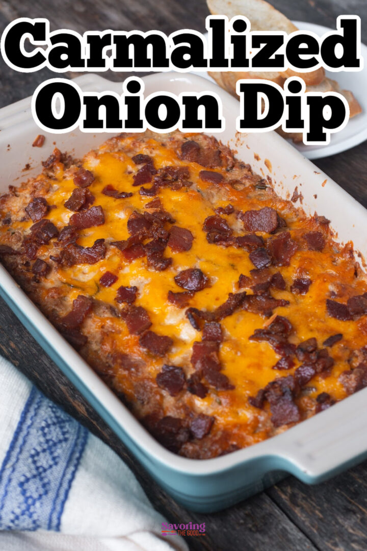 Rectangular baking dish with caramelized onion dip topped with melted cheese and bacon pieces, placed on a wooden surface.