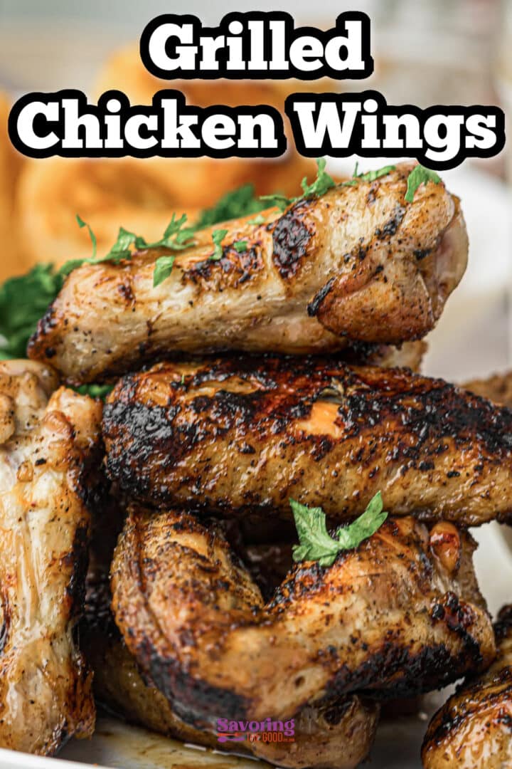 A plate of grilled chicken wings garnished with fresh herbs, shown close-up with a toasted appearance.