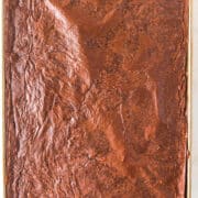 A large rectangular baking sheet filled with chocolate frosted Sheet Pan Brownies, viewed from above, showcasing a rich and decadent dessert.