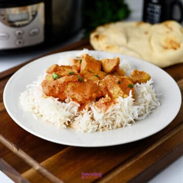Slow cooker chicken tikka masala in a white bowl over rice, garnished with cilantro