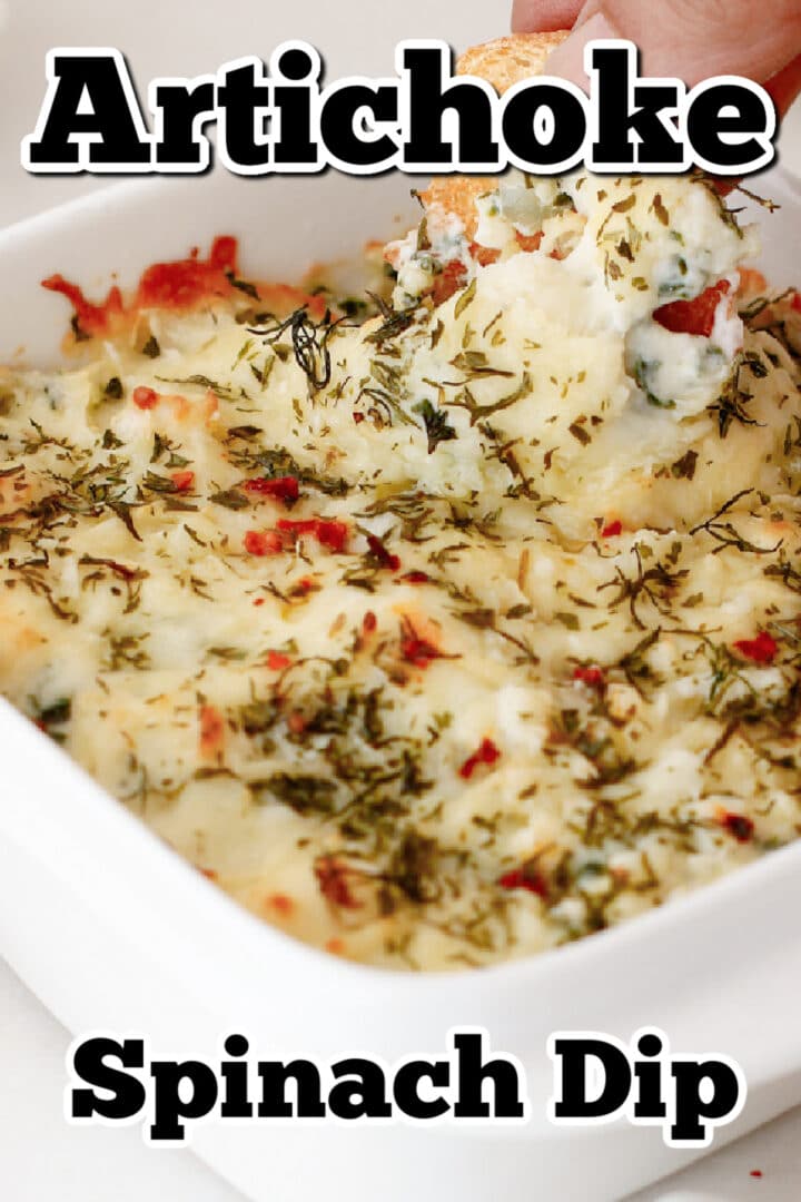 A hand dips a piece of bread into a baked artichoke spinach dip in a white dish, topped with herbs and seasonings. Text reads "Artichoke Spinach Dip.