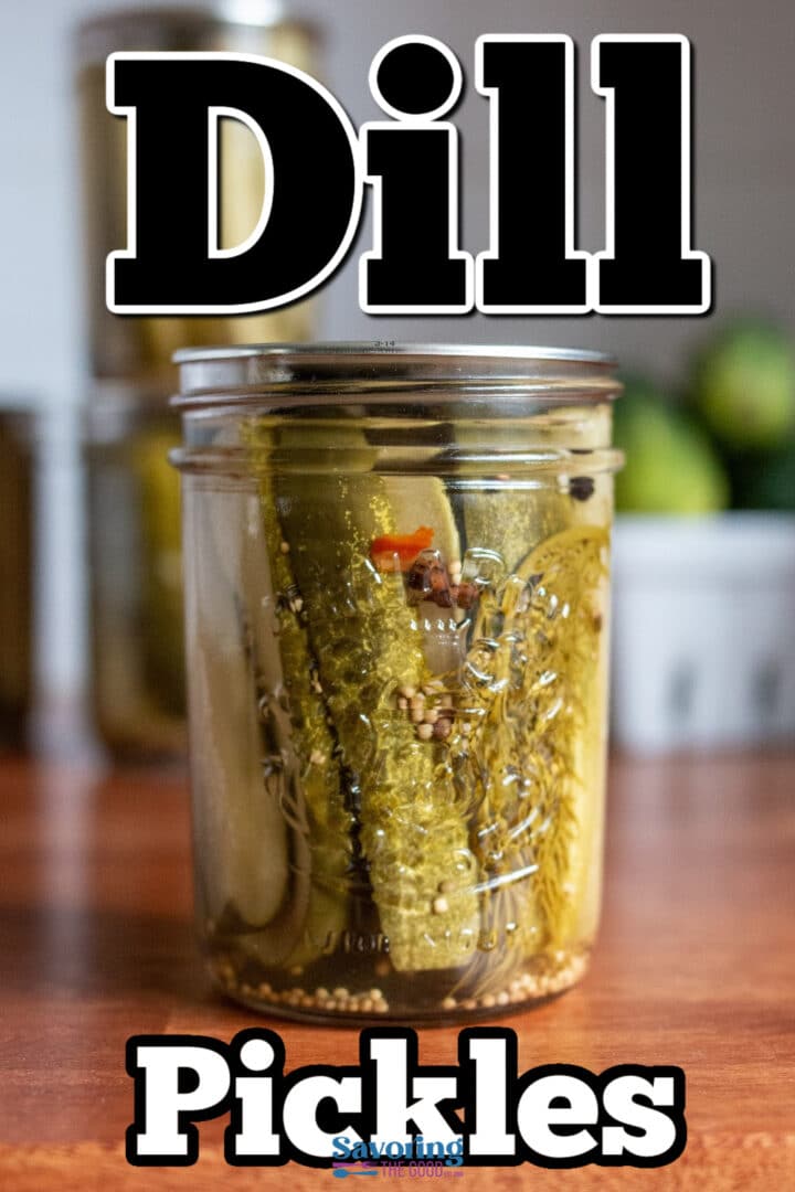 A glass jar filled with dill pickles sits on a wooden surface, with large text reading “Dill Pickles” over the image.