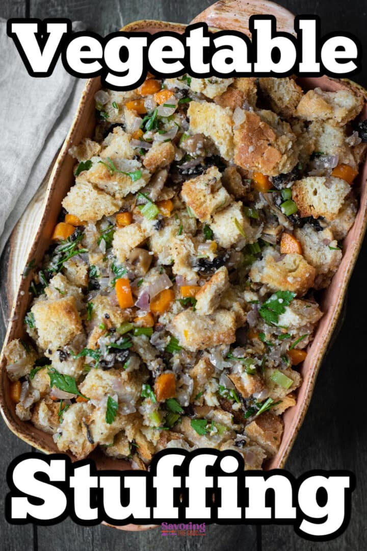A baking dish filled with vegetable stuffing made of bread cubes, chopped veggies, and herbs.