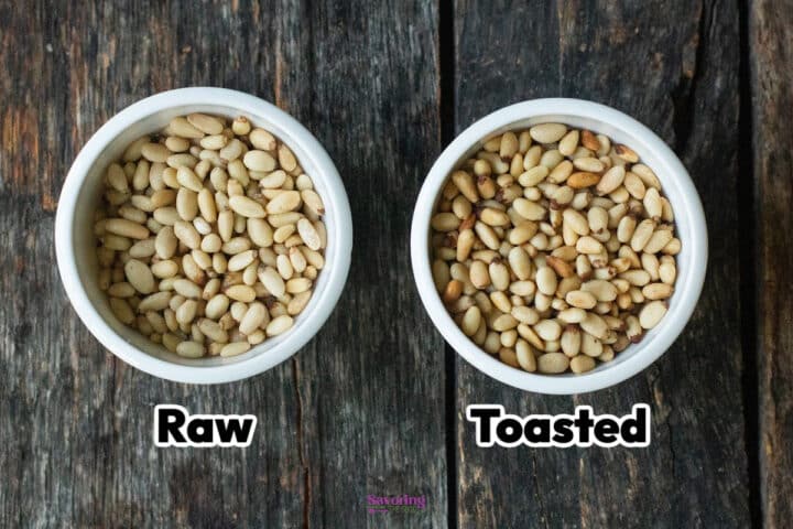 Two white bowls on a dark wooden surface, one containing raw pine nuts and the other containing toasted pine nuts, labeled